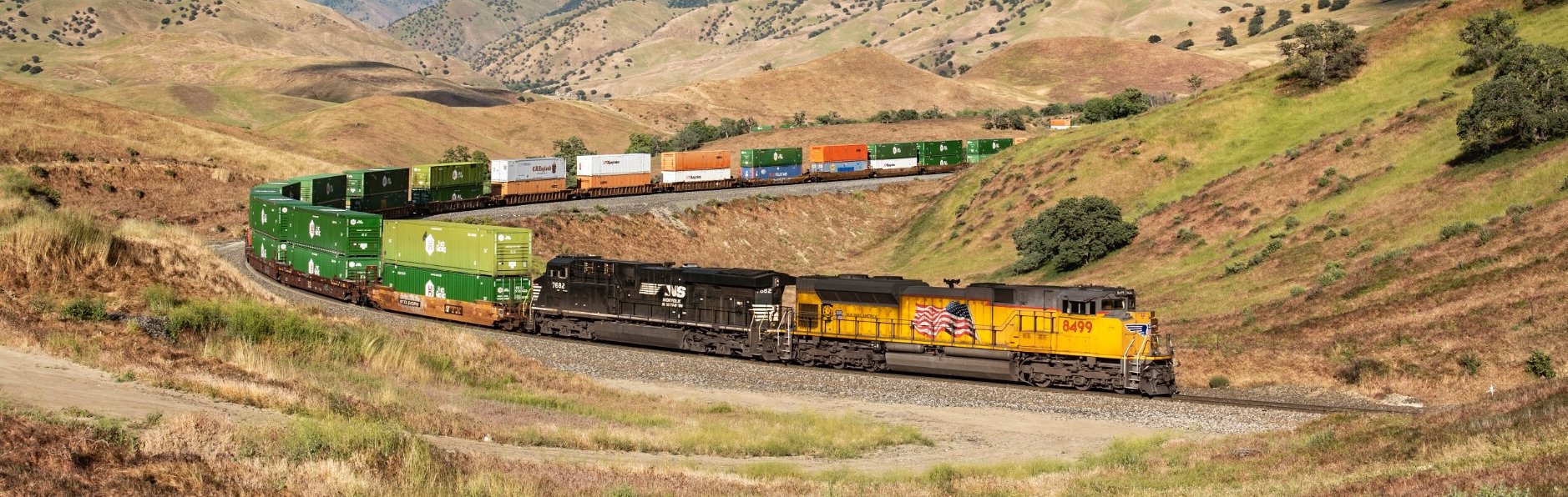 Union Pacific and Norfolk Southern intermodal train traveling through a mountain landscape