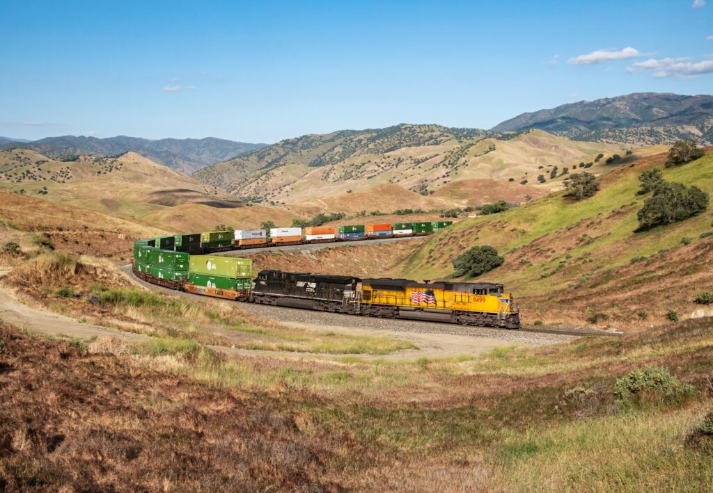 Union Pacific and Norfolk Southern intermodal train traveling through a mountain landscape