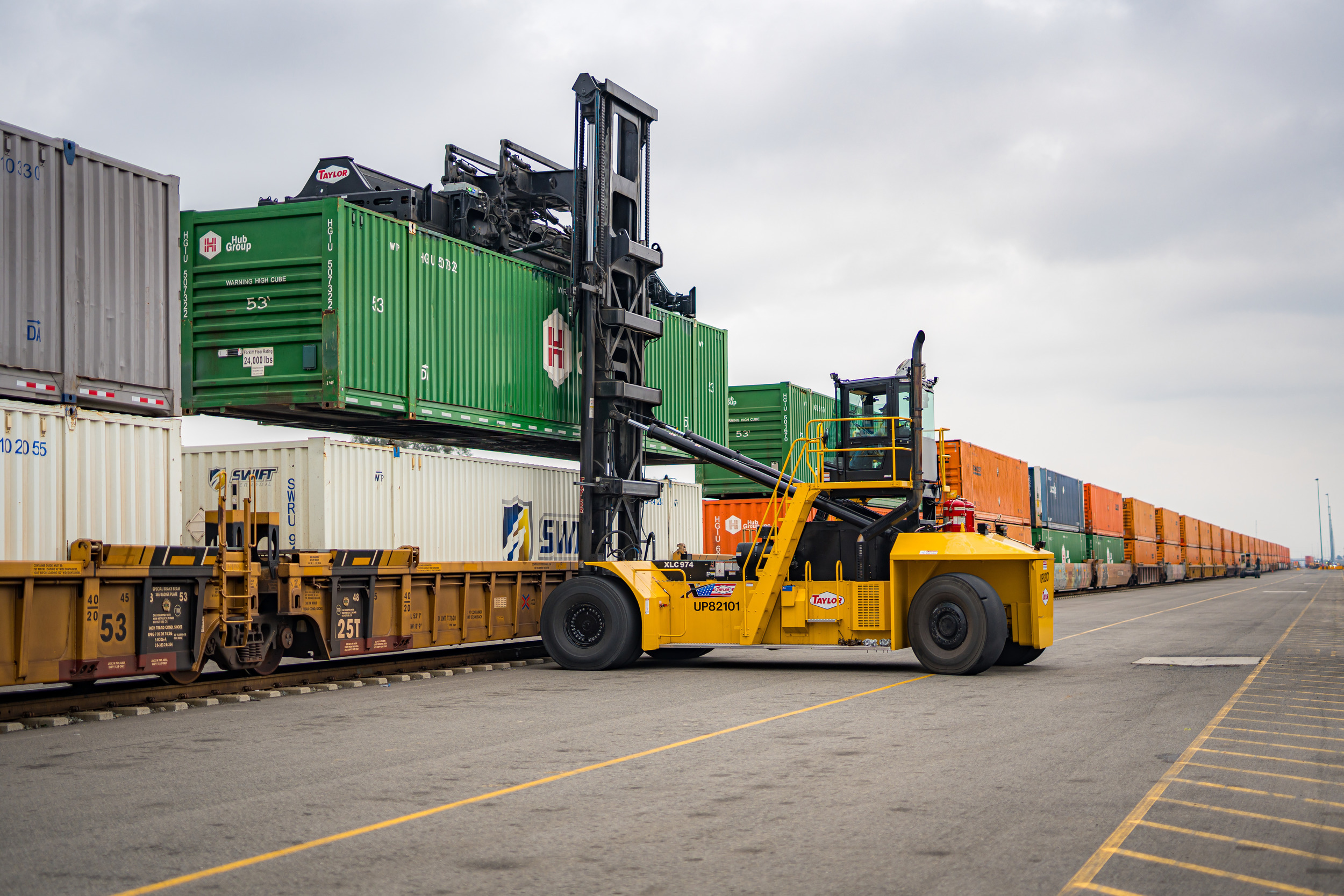 Union Pacific intermodal equipment moving shipping containers beside a freight train