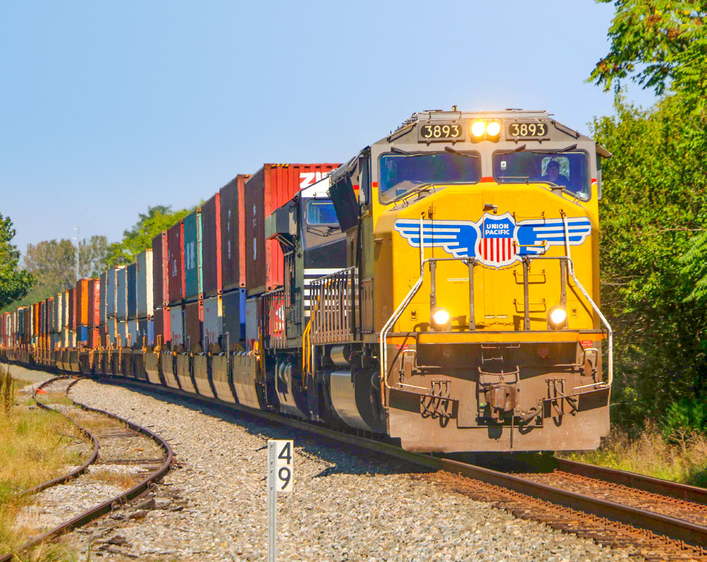 Union Pacific locomotive 3893 leading an intermodal freight train.
