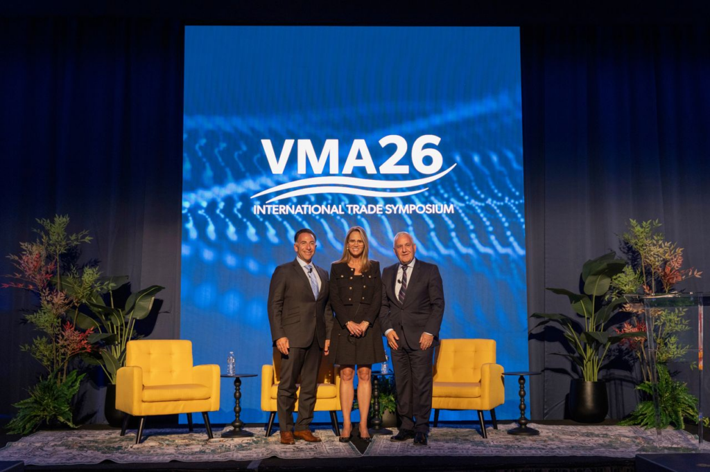 Three speakers onstage at the VMA26 International Trade Symposium.